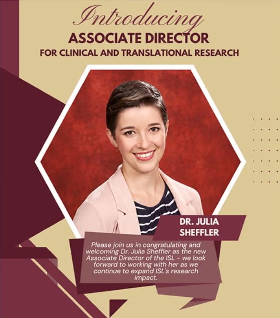 An announcement graphic introducing Dr. Julia Sheffler as the new Associate Director for Clinical and Translational Research. Set against a gold background with geometric garnet accent shapes on the left, the central feature is a hexagonal portrait of Dr. Sheffler smiling, with short brown hair, wearing a pink blazer over a striped top against a red backdrop.  Above the photograph, elegant cursive and bold maroon text reads "Introducing ASSOCIATE DIRECTOR FOR CLINICAL AND TRANSLATIONAL RESEARCH." Below the 