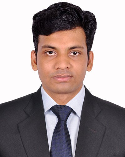 Professional passport-style headshot of Md Selim Reza looking directly at the camera. He has dark hair styled to the side and is wearing a black suit jacket, light blue dress shirt, and a dark blue tie against a clean white background.   